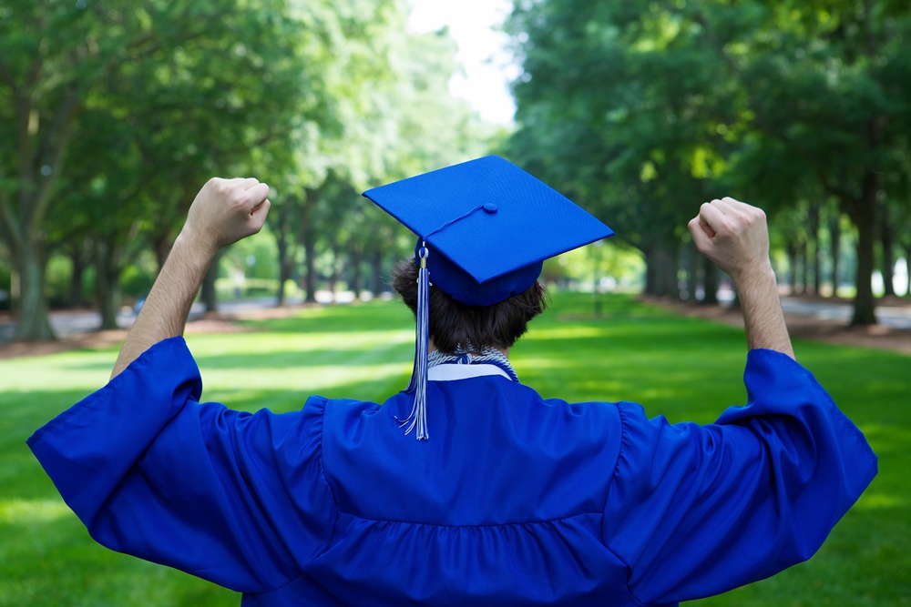 graduate-student-blue-mantle-holding-his-fists-up.jpg